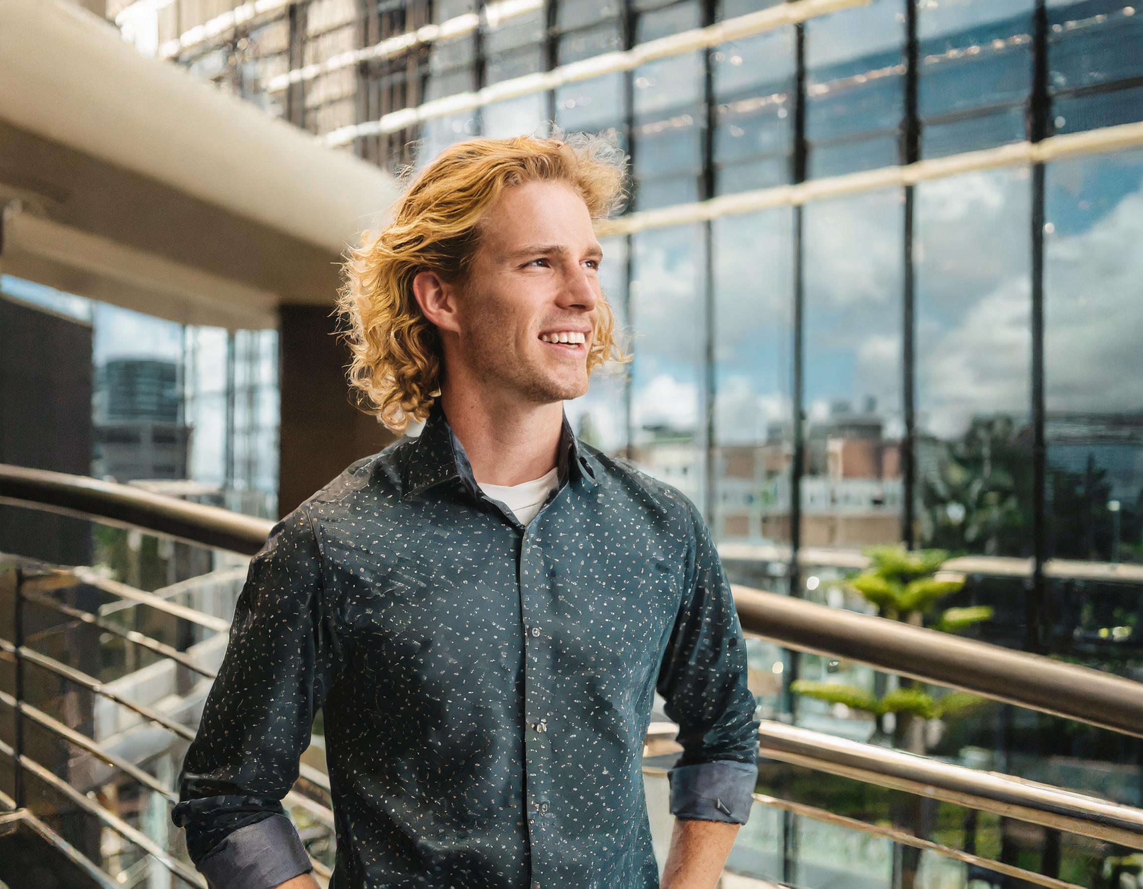 Mann mit freundlichem Lächeln, in einem Büro, in Business-Kleidung